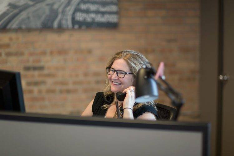 professional smiling on phone at desk
